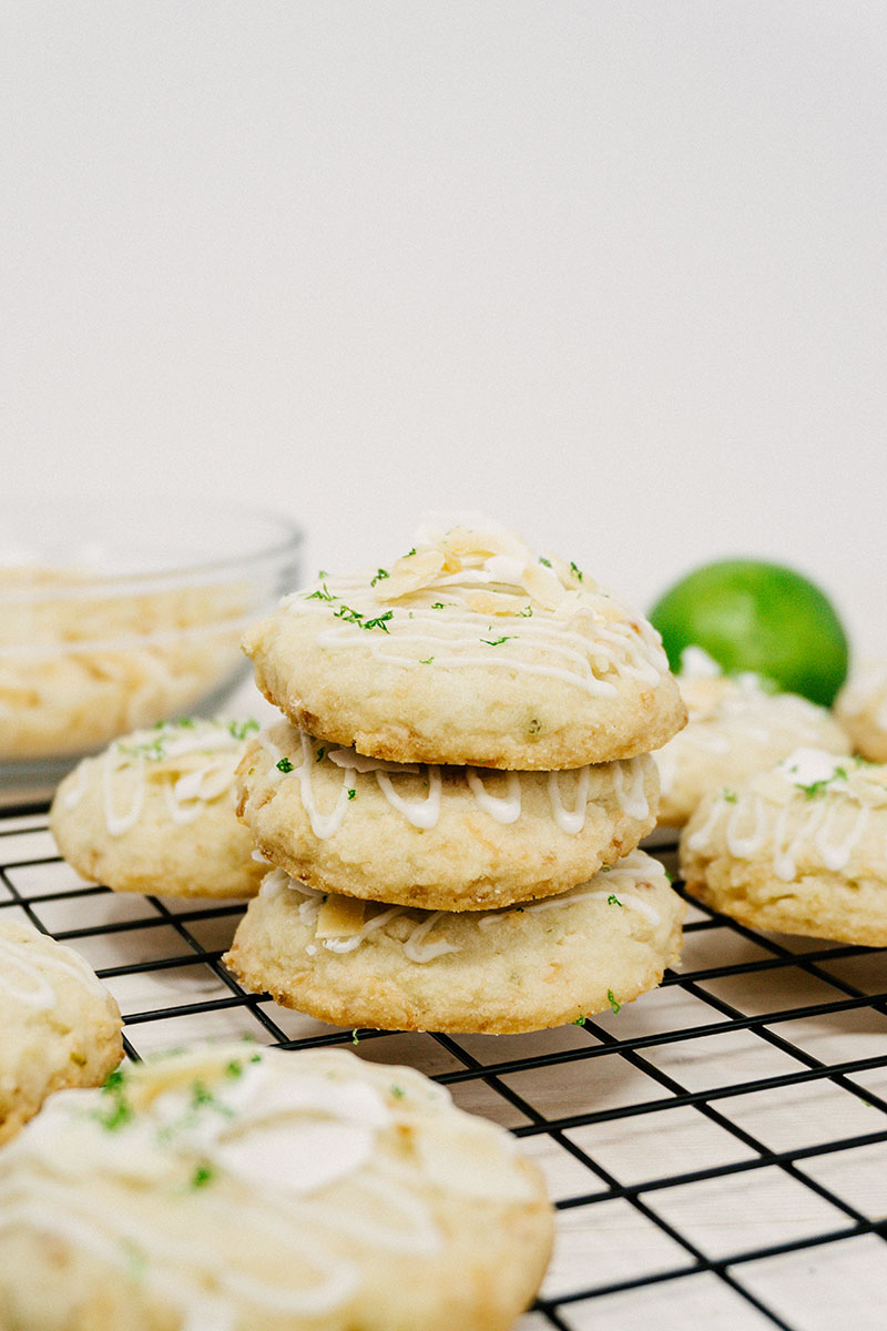 taste before beauty coconut lime shortbread stacked on top of eachother on a grid wire cooling rack