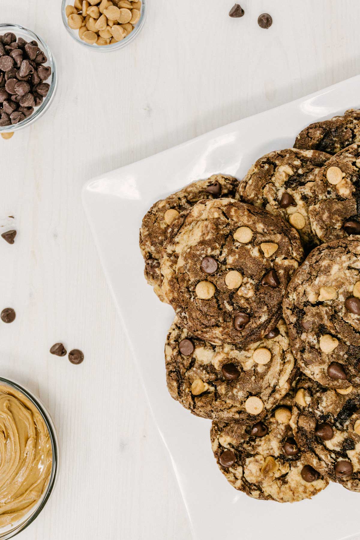 pennsylvania tango peanut butter cookies on plate with peanut butter and chocolate chips surrounding the cookies