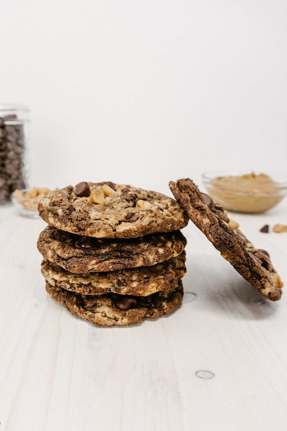 stacked pennsylvania tango peanut butter cookies with chocolate and peanut butter chips and peanut butter in the back