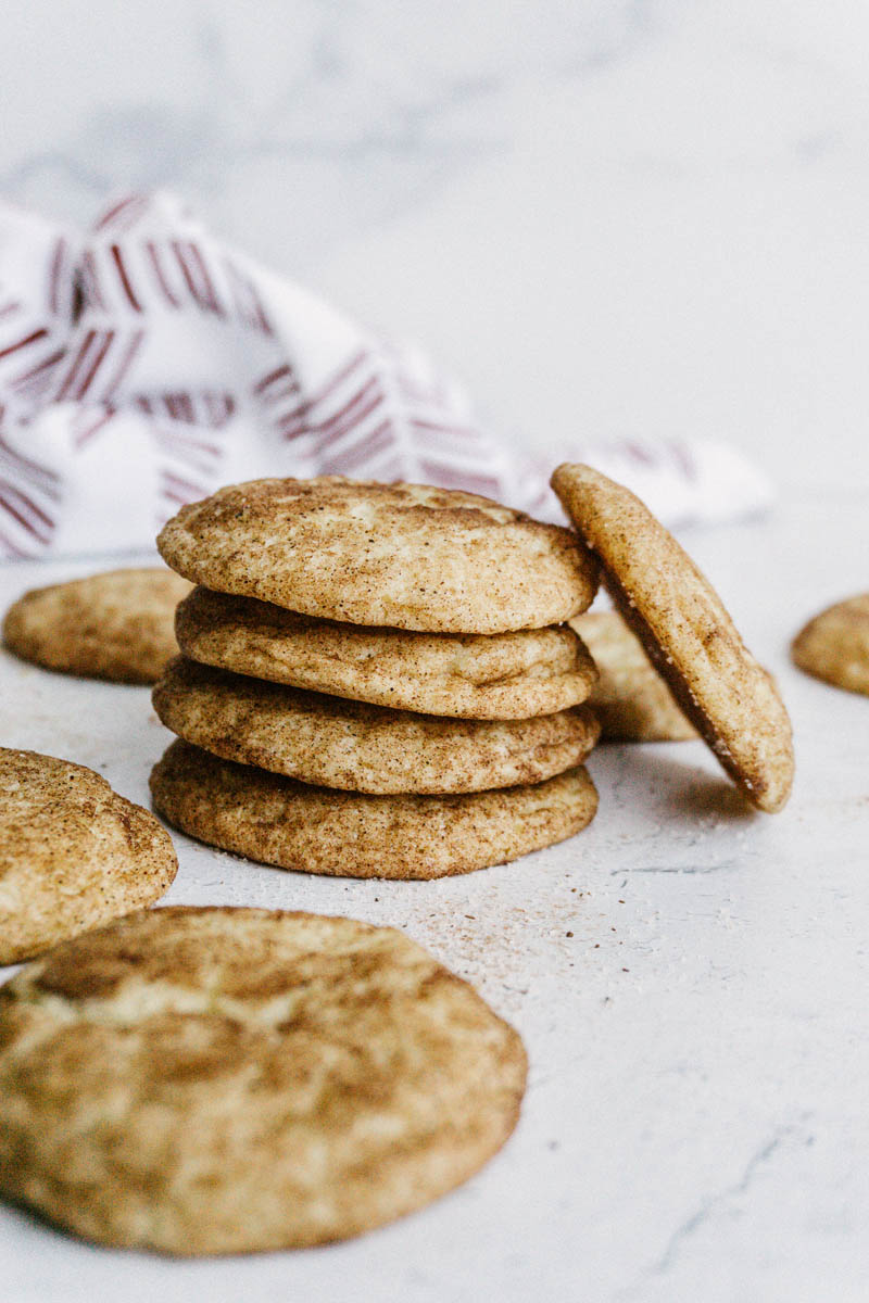taste before beauty the best snickerdoodle cookies on table with kitchen towel stacked up