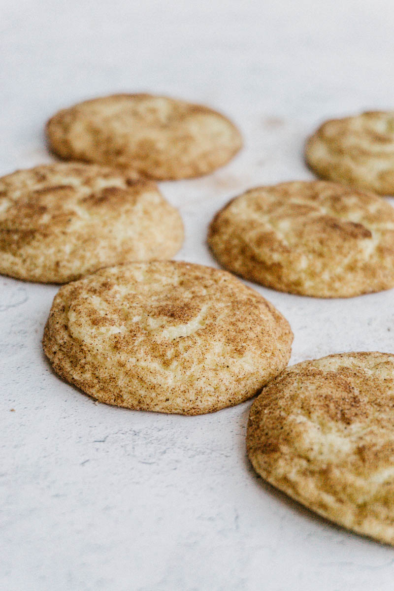 taste before beauty the best snickerdoodle cookies layed out on table with cinnamon and sugar