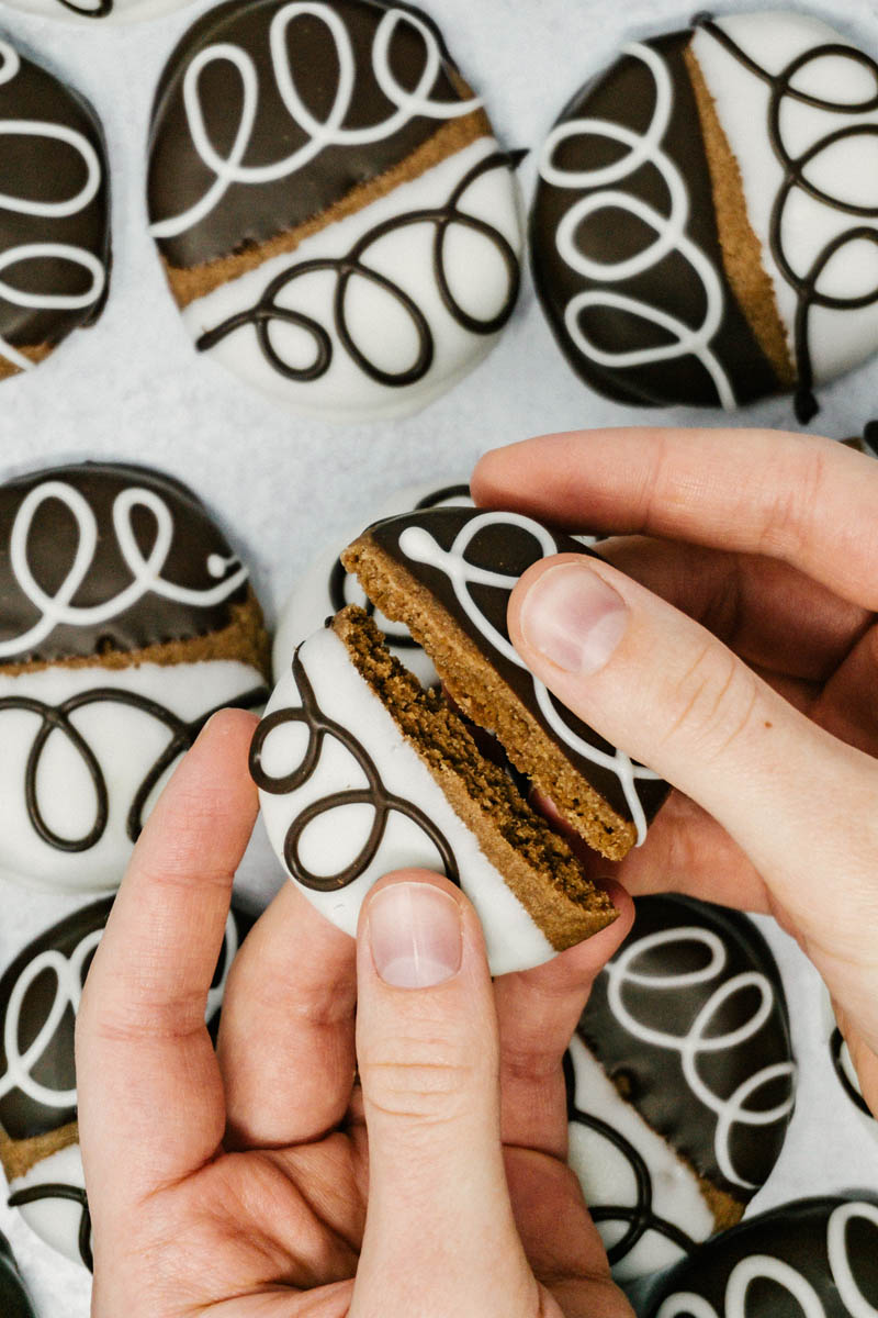 taste before beauty black and white chocolate shortbread cookies on table with white and chocolate drizzles split in half