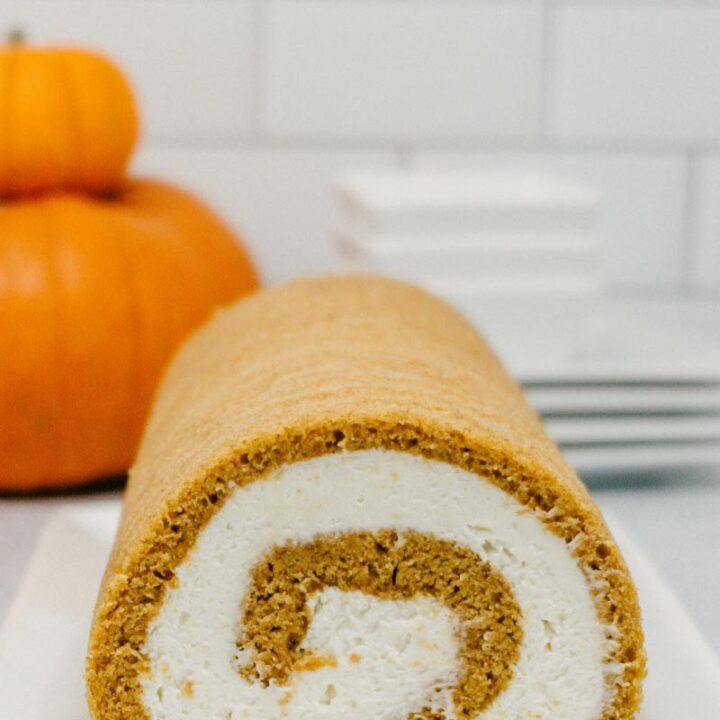 taste before beauty pumpkin roll with cream cheese frosting with pumpkins stacked with cream cheese whipped cream frosting