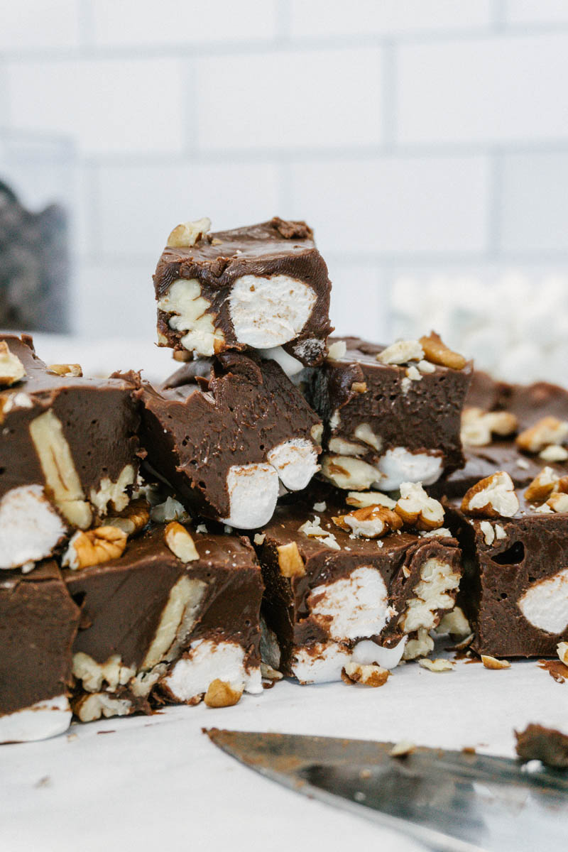 taste before beauty chocolate rocky road fudge pieces cut and stacked on top of each other with marshmallows and nuts inside