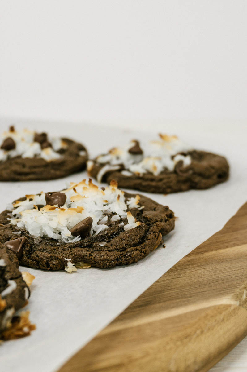chocolate coconut cookies on parchment paper with chocolate chips