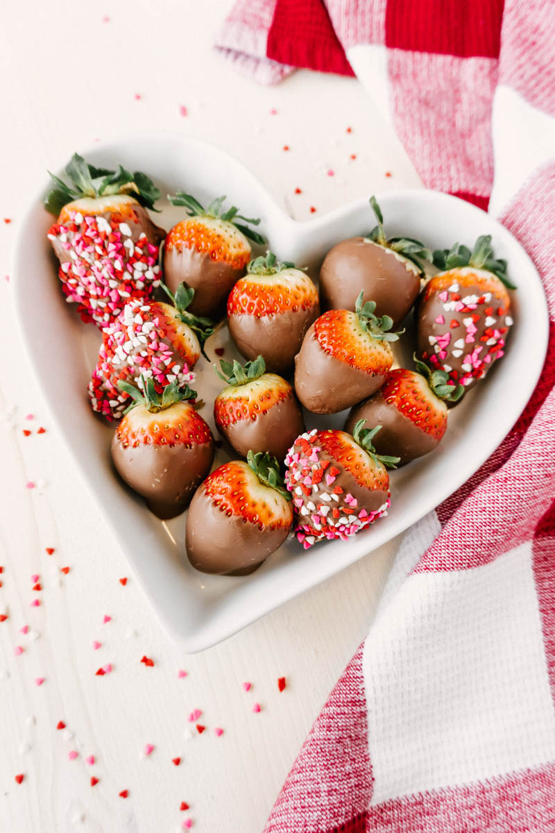 taste before beauty chocolate dipped strawberries in heart dish with sprinkles around