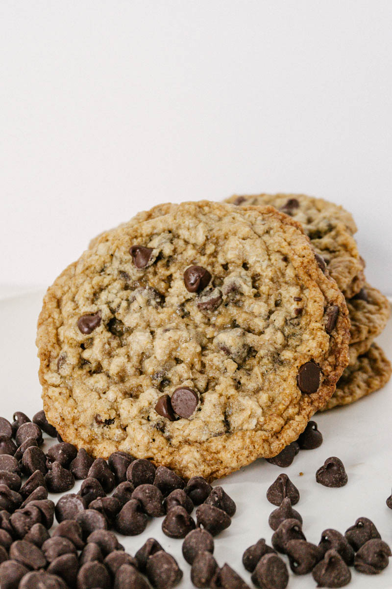 taste before beauty oatmeal chocolate chip cookie stacked on each other with chocolate chips