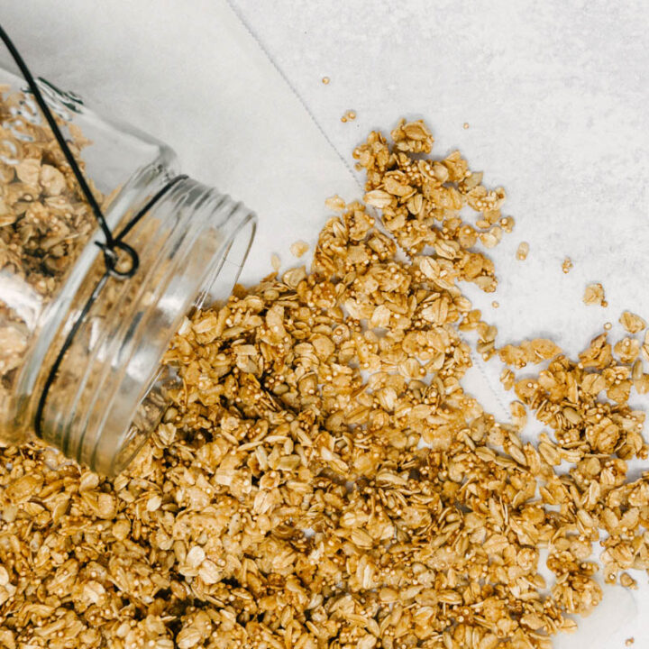 quinoa granola spread out on table from jar