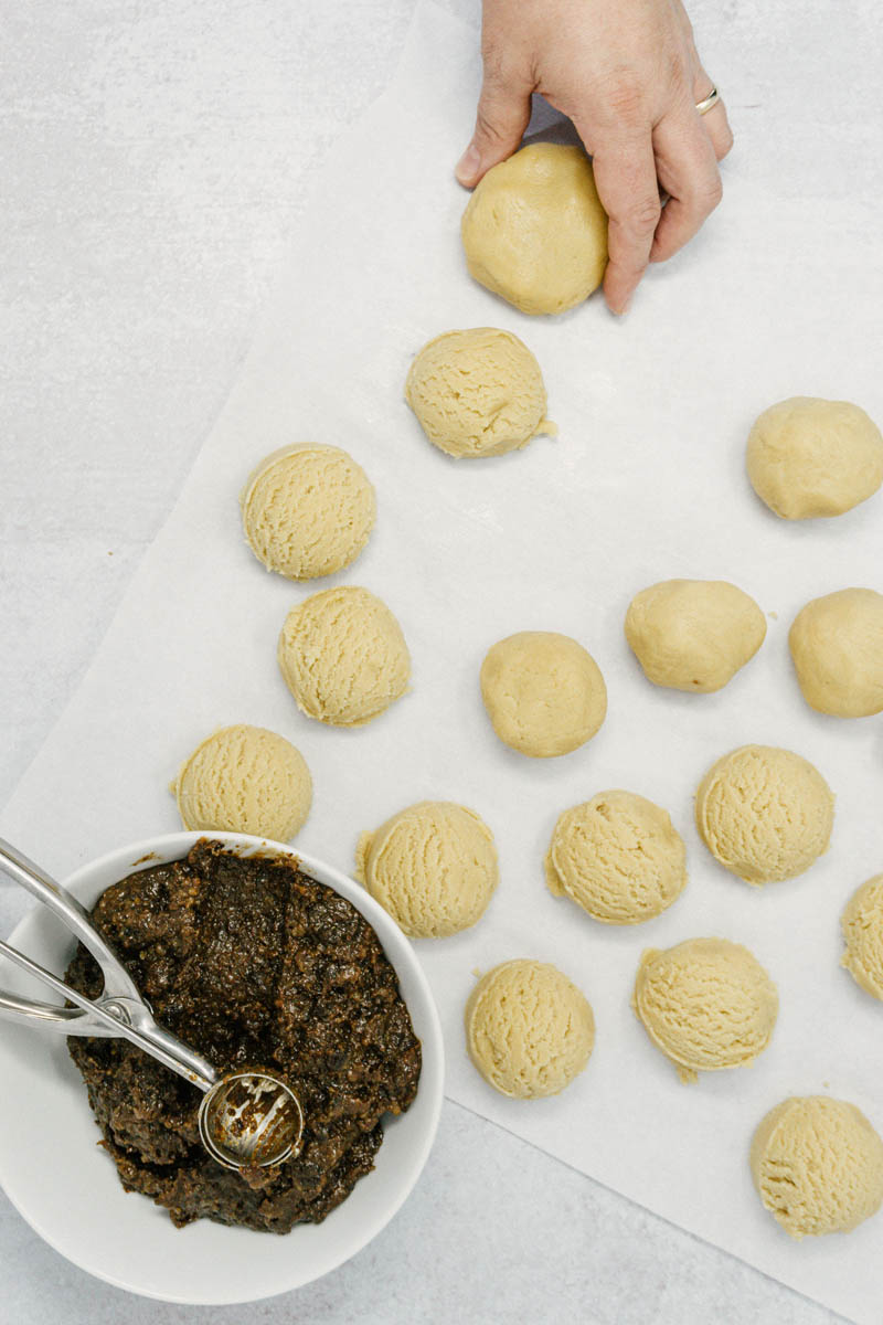 taste before beauty raisin filled cookie dough balls on parchment paper with bowl of raisins