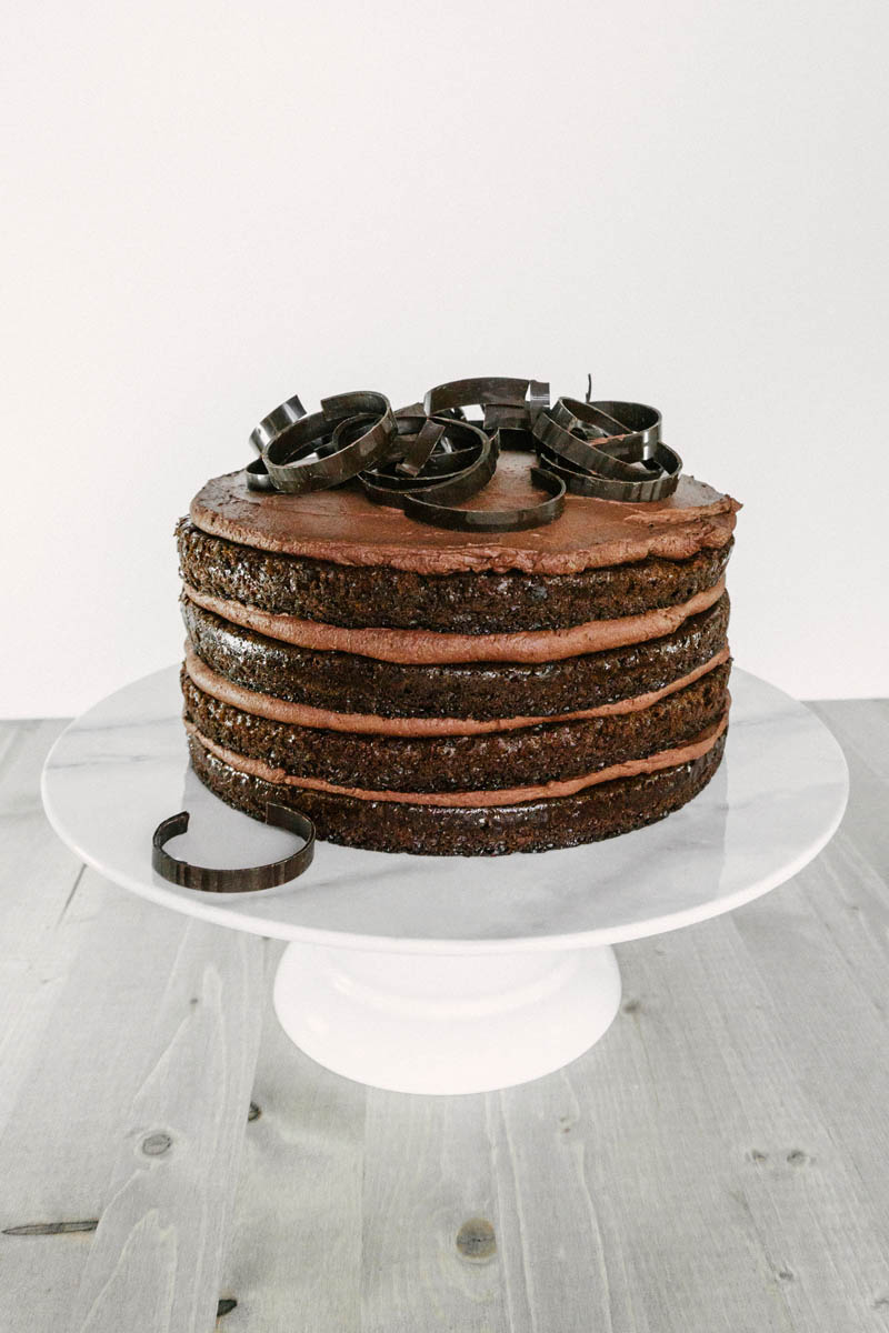 taste before beauty rich chocolate cake with easy chocolate mousse on stand with chocolate swirls