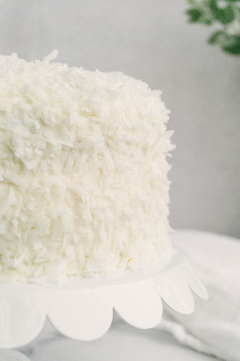 taste before beauty sweet coconut cake on cake stand with coconut flakes