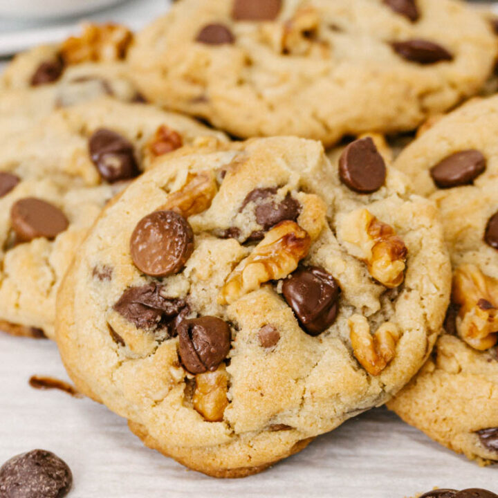 taste before beauty triple chocolate chip walnut cookies stacked on parchment paper