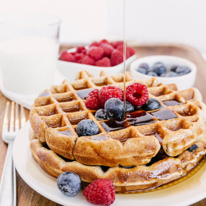 taste before beauty whole wheat waffles on plate with blueberries raspberries milk with pouring syrup
