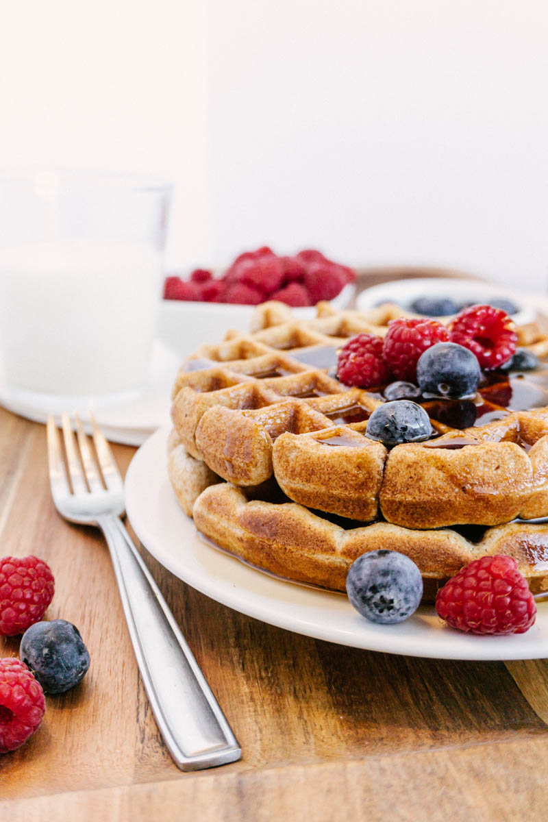 taste before beauty whole wheat waffles on plate with blueberries raspberries milk and syrup
