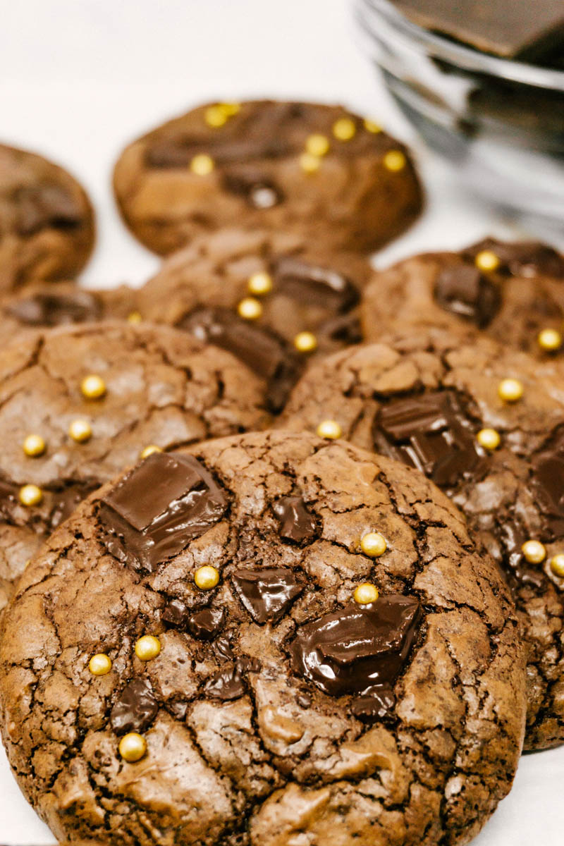 aztec wonder chocolate cayenne cookies layed on table with gold sprinkles