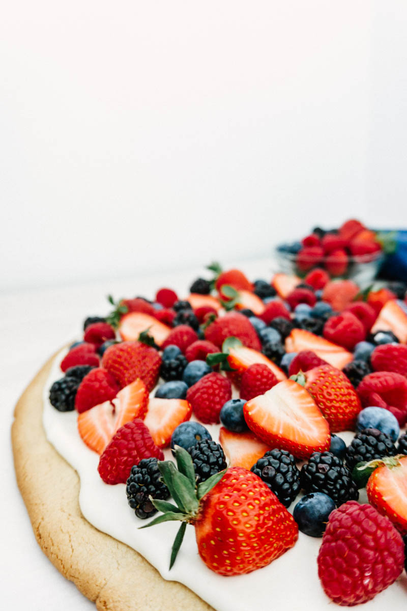 easy fruit pizza with berries and cream on table