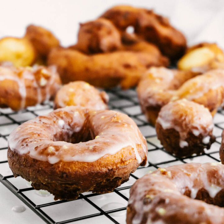 lemon greek yogurt cake donuts on wire rack with glaze