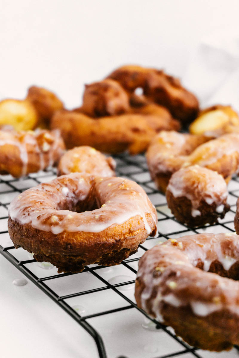 lemon greek yogurt cake donuts on wire rack with glaze