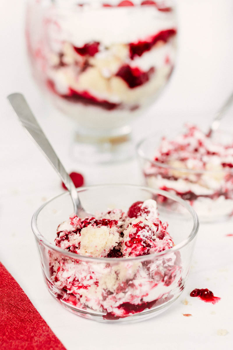raspberry trifle in a glass dish with a spoon