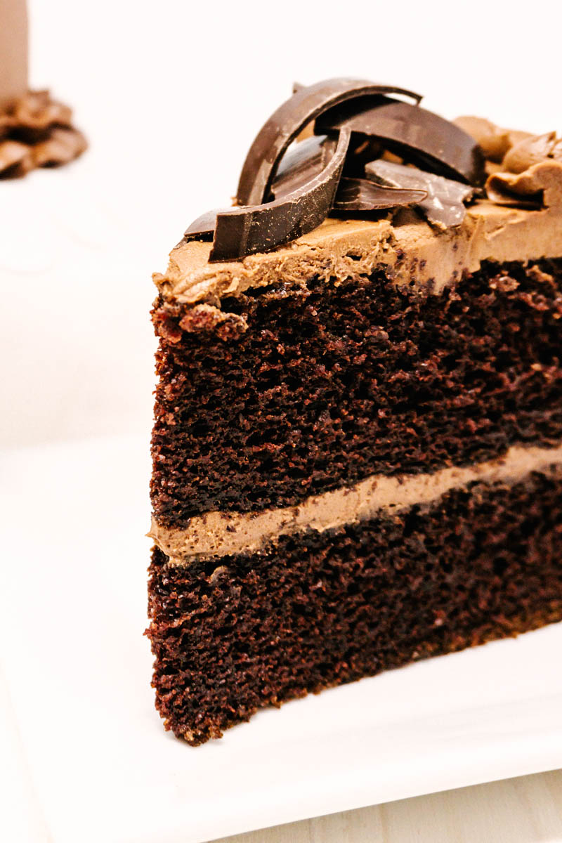 chocolate cake with chocolate buttercream frosting on plate with chocolate shavings