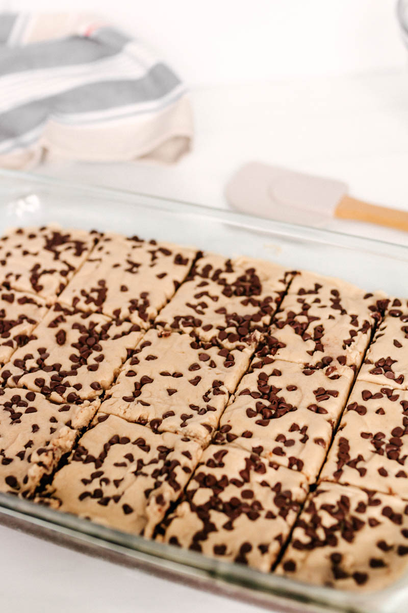 cookie dough brownies cut into squares in glass baking pan