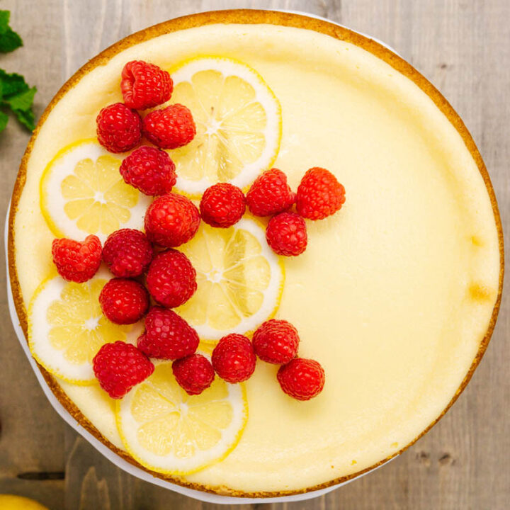new york cheesecake with lemons and raspberries on the table