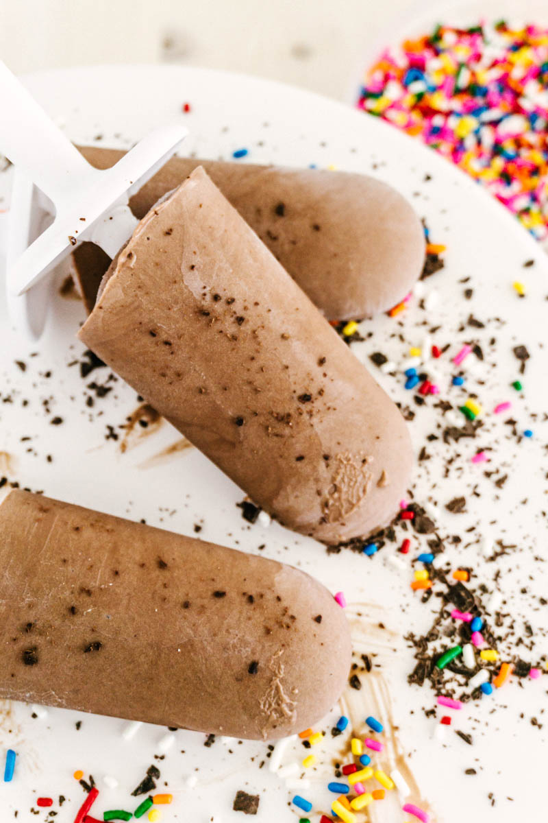 fudgesicles on a plate with chocolate and sprinkles