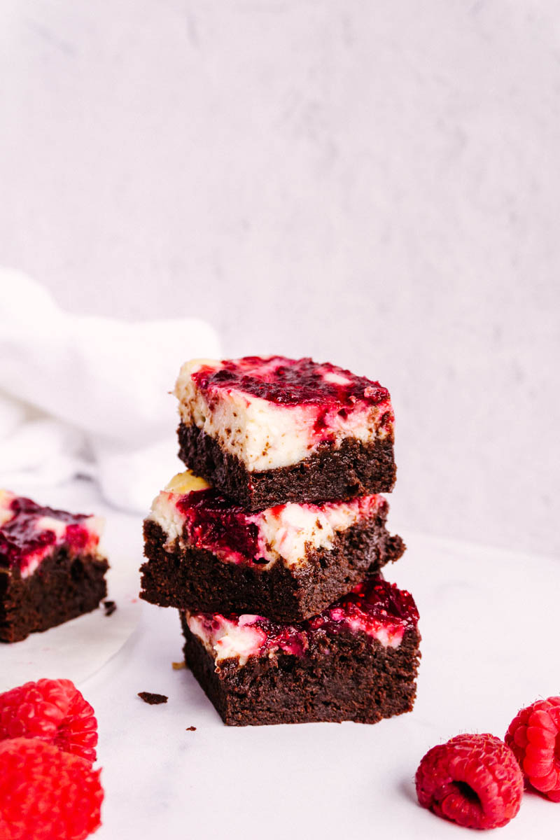 raspberry cheesecake brownies stacked on each other