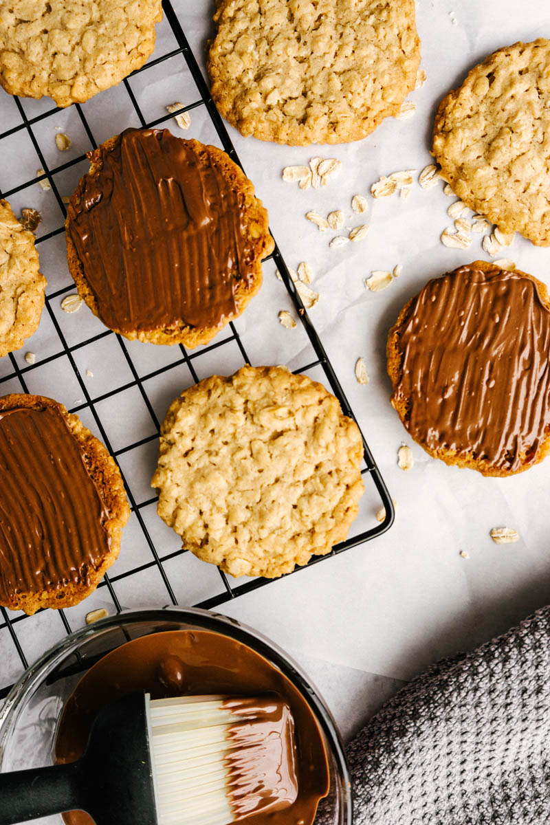 copycat hobnobs oatmeal crumble cookies on table with chocolate coating