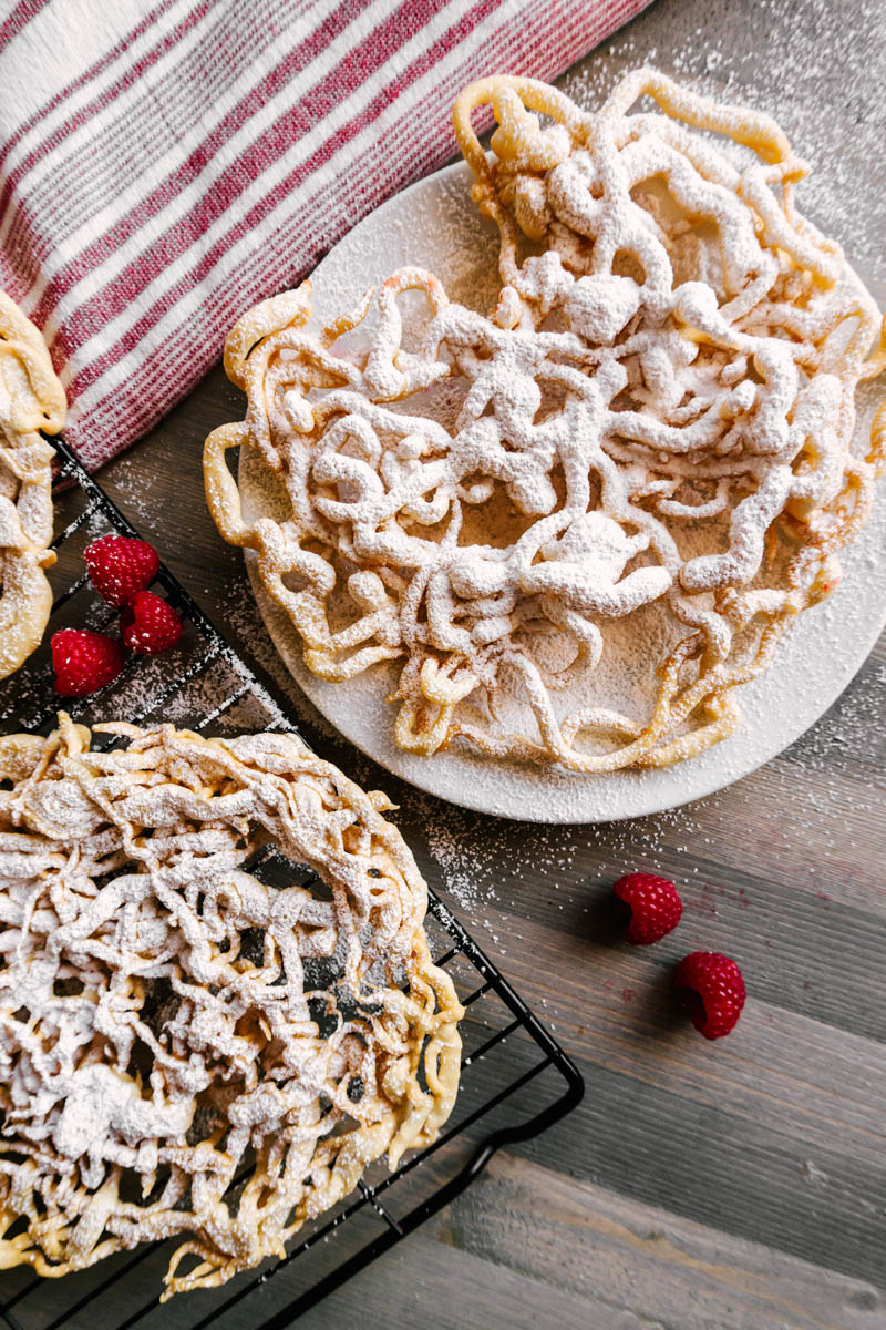 funnel cakes on cooling wire rack and plate