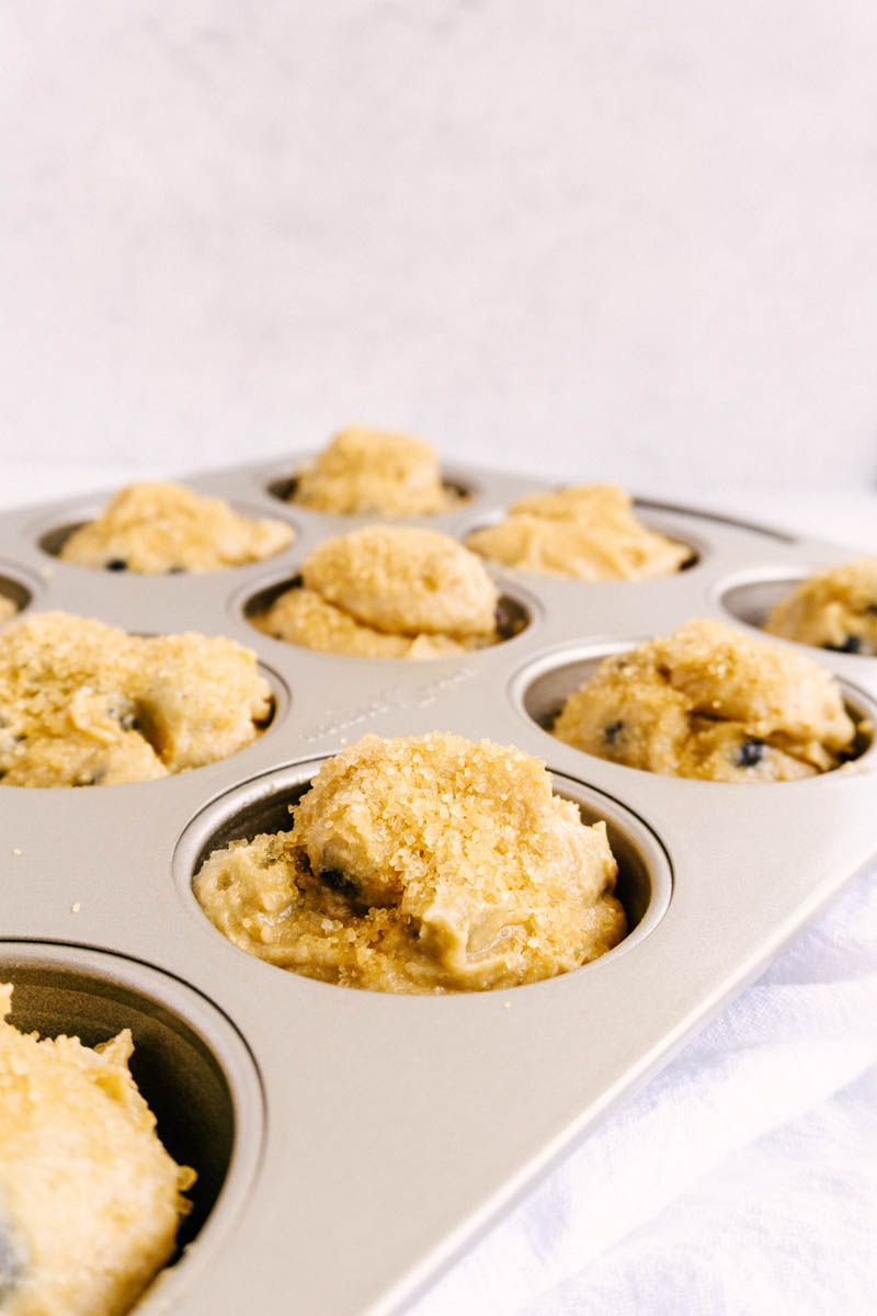 scooped lemon blueberry muffins into muffin tin pan