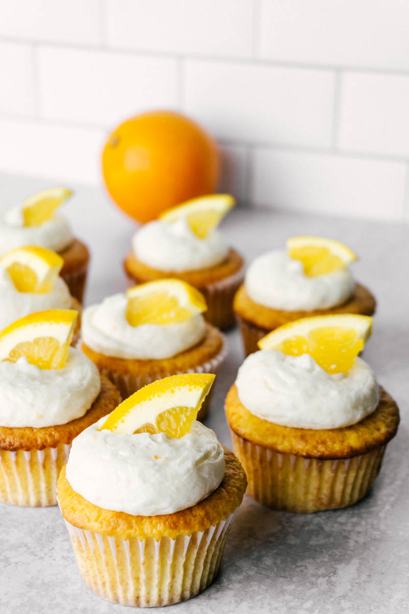 orange cream cupcakes with an orange in the back