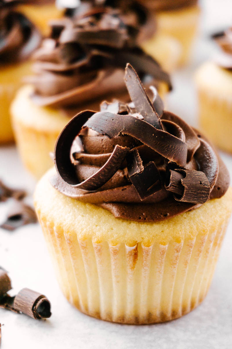 upclose of yellow cupcakes with chocolate buttercream frosting