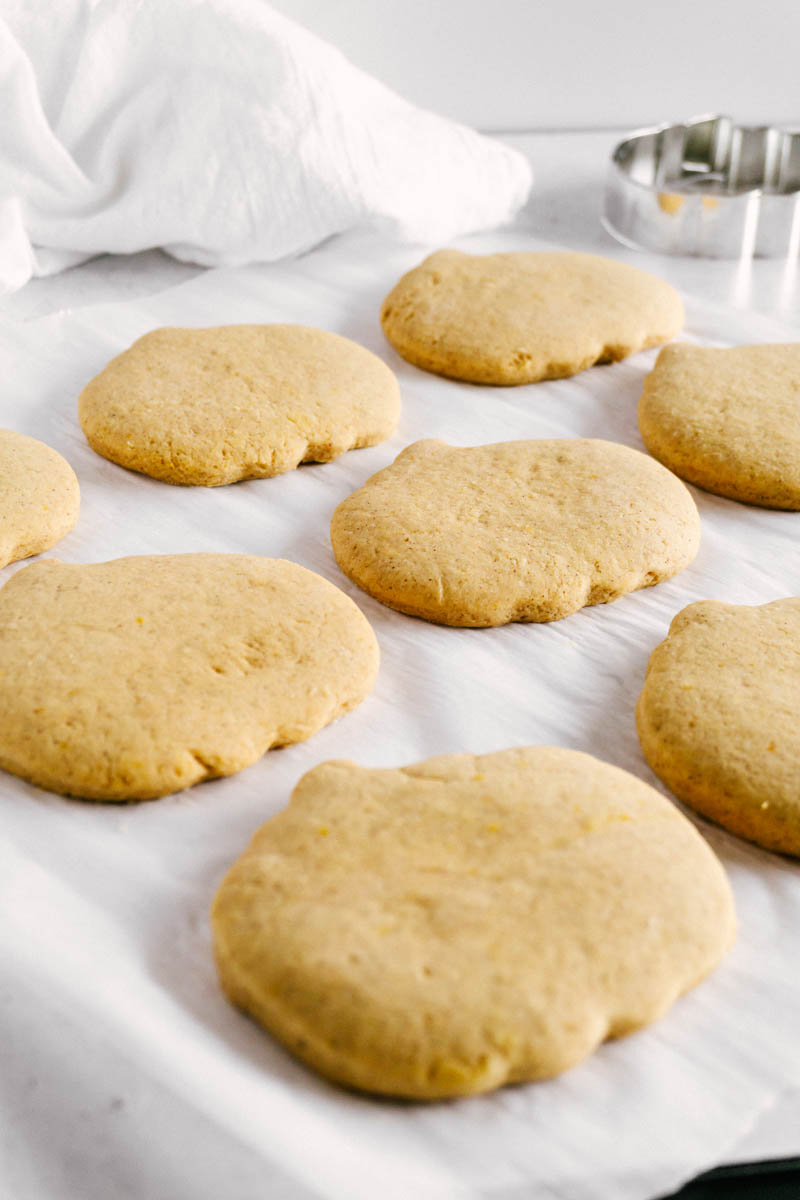 unfrosted pumpkin sugar cookies on parchment paper
