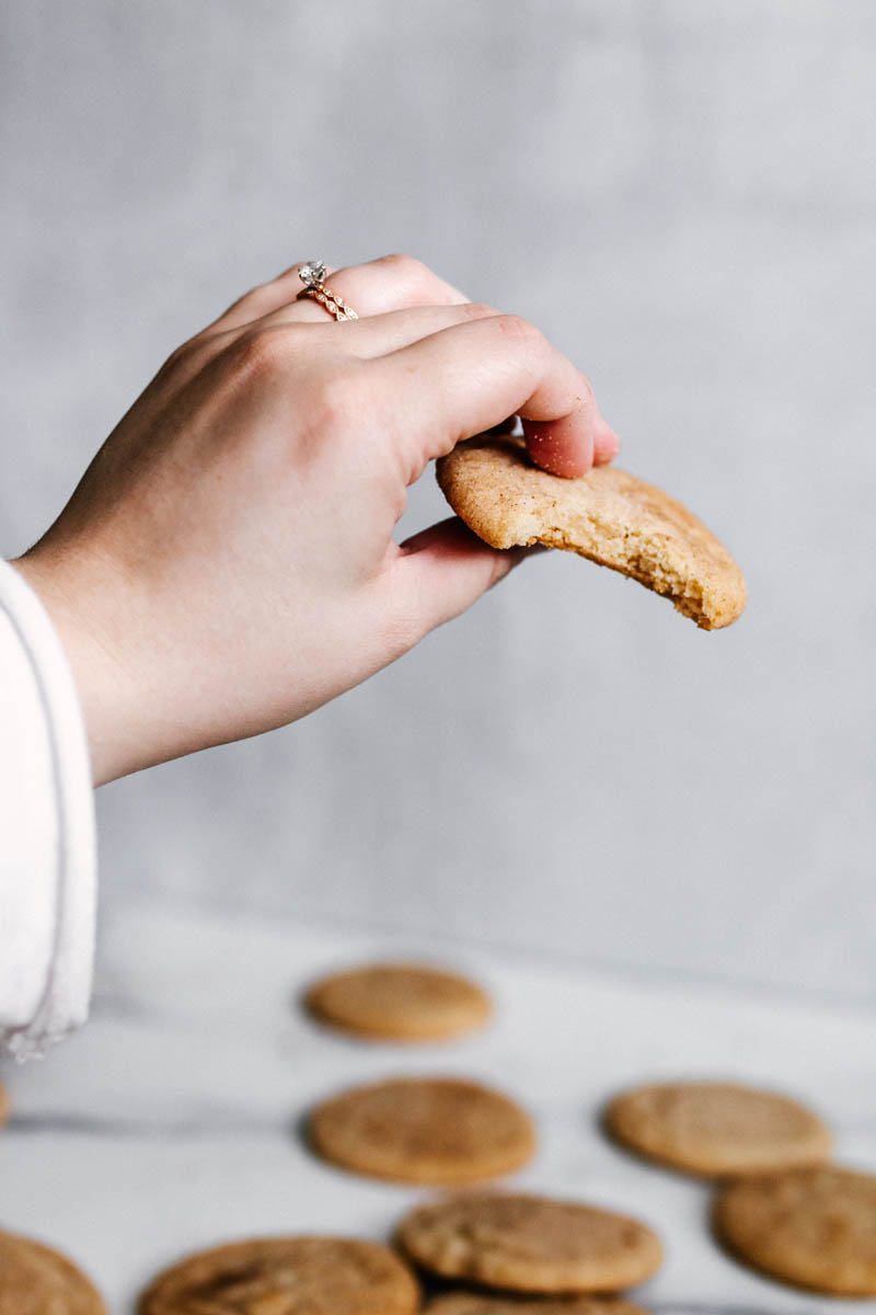 a hand holding a bitten chai sugar cookie