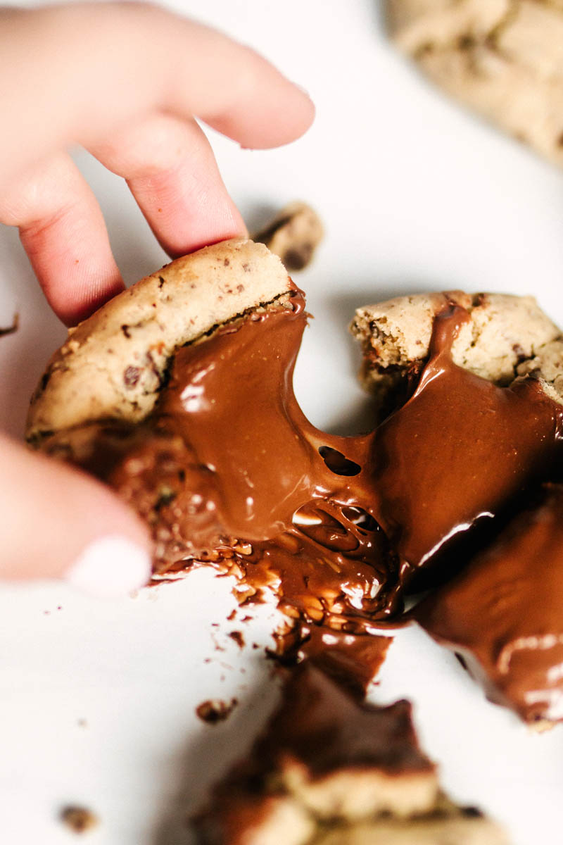 pulling apart a nutella cookie, with gooey chocolate pulling away