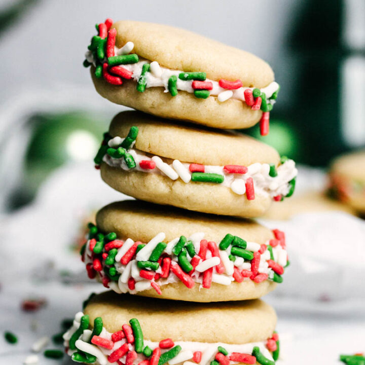 christmas sprinkle sandwich cookies stacked on top of each other