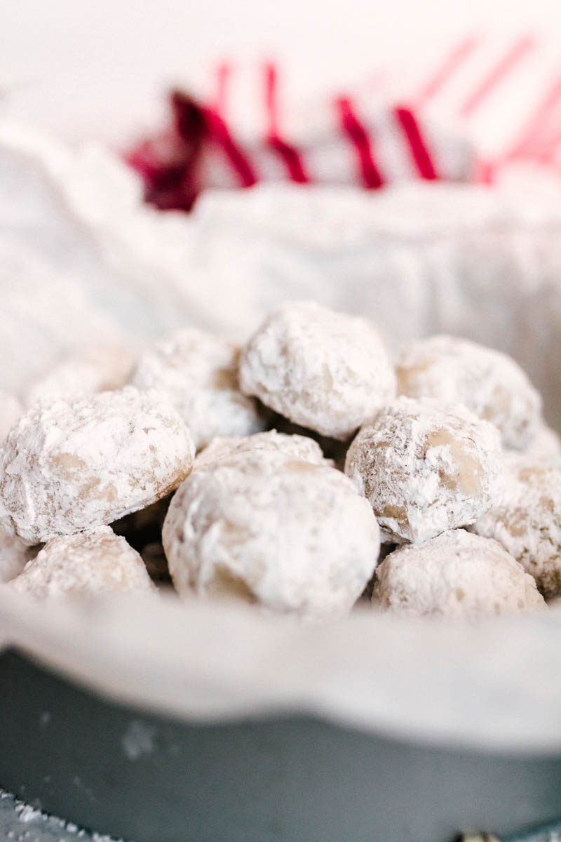 multiple snowball cookies on a pan with parchment paper