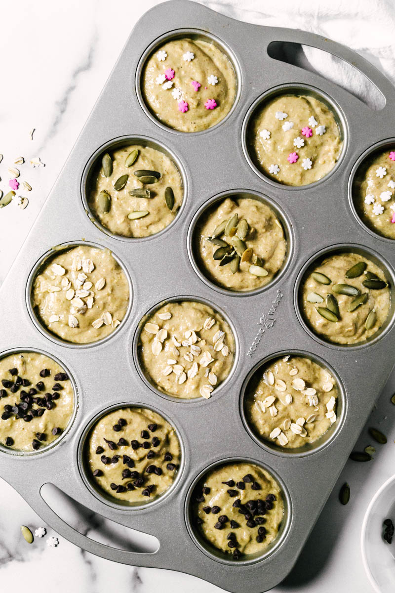 healthy banana muffin batter in pans with toppings