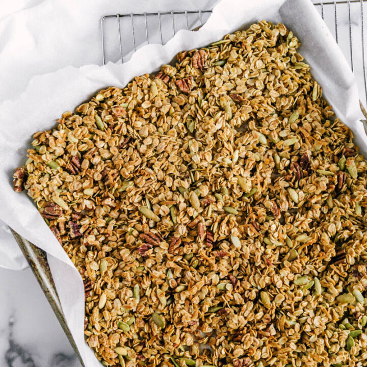 orange cardamom granola in a baking pan on a table