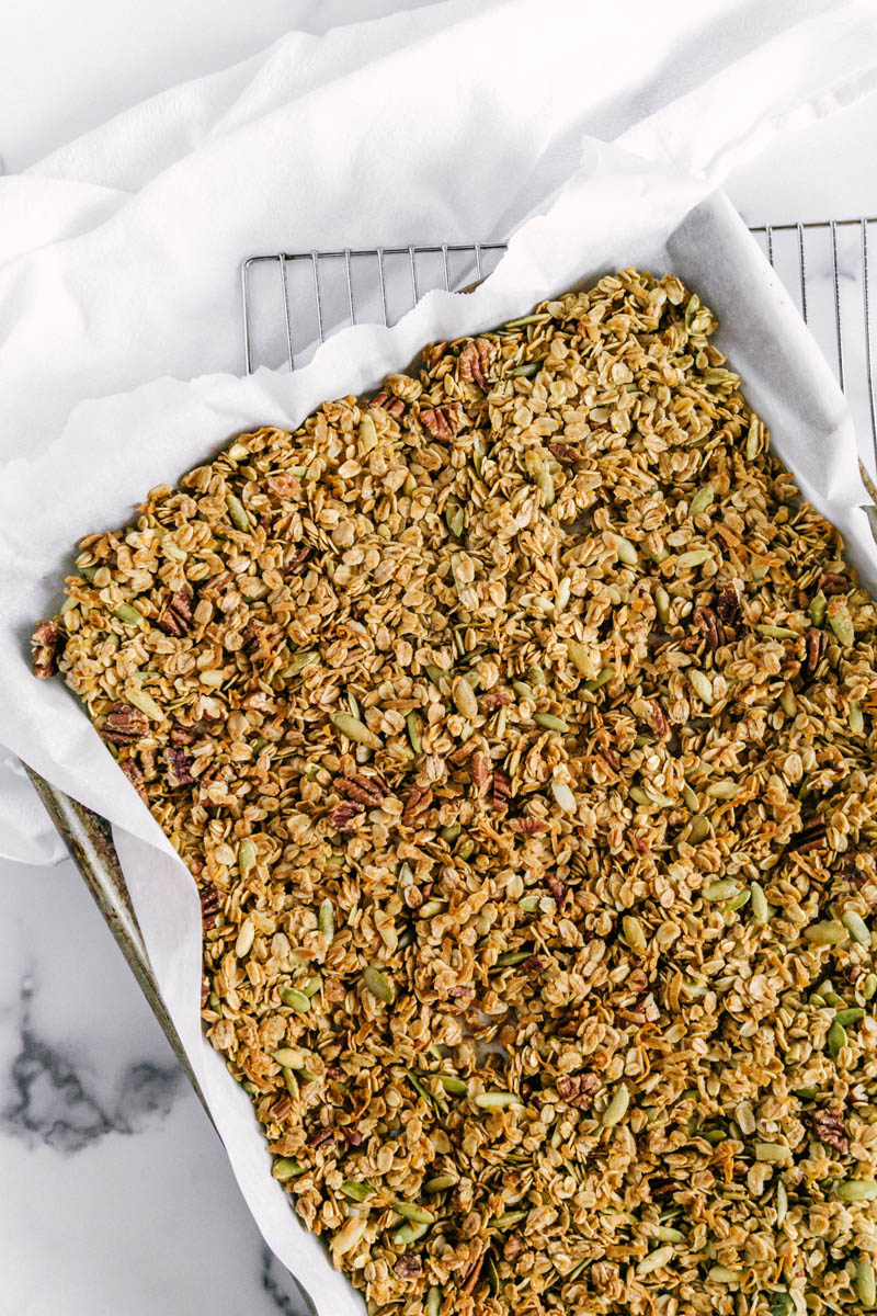 orange cardamom granola in a baking pan on a table