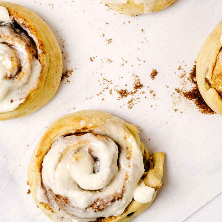 4 cinnamon rolls on parchment paper